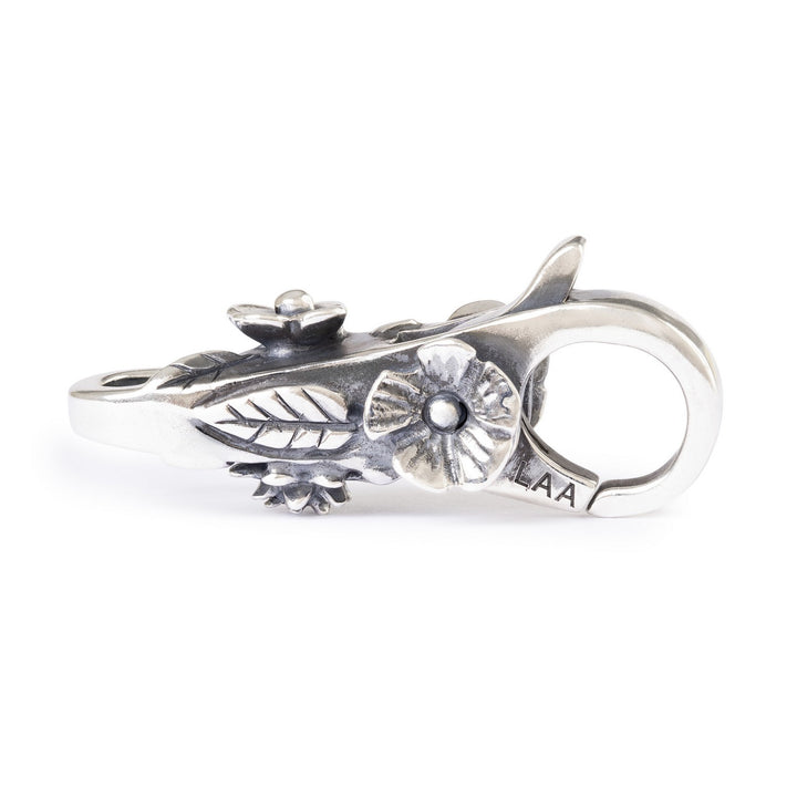 Silver clasp with intricate design on a white background