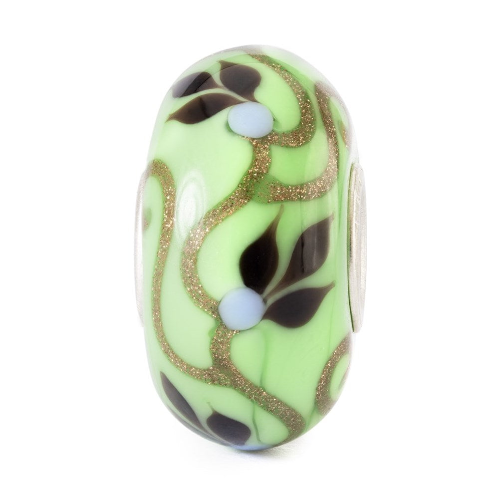 Decorative bead with green, brown, and gold patterns on a white background