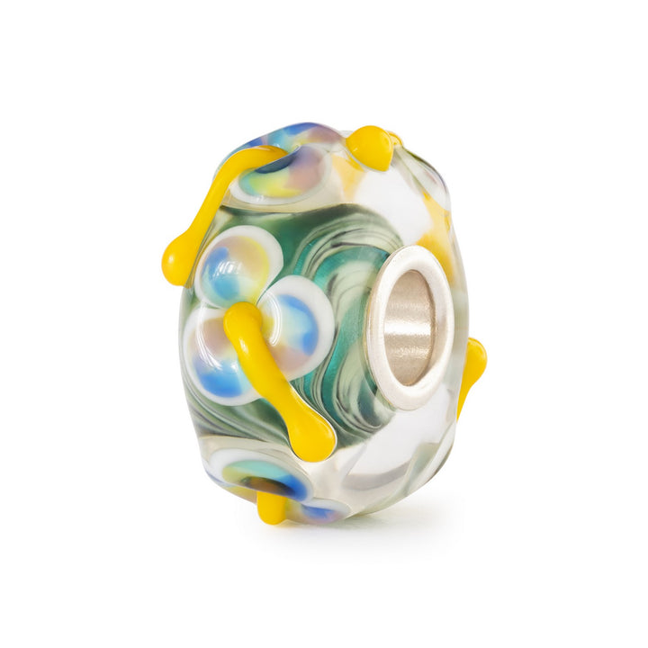 Glass bead charm with yellow accents on a white background