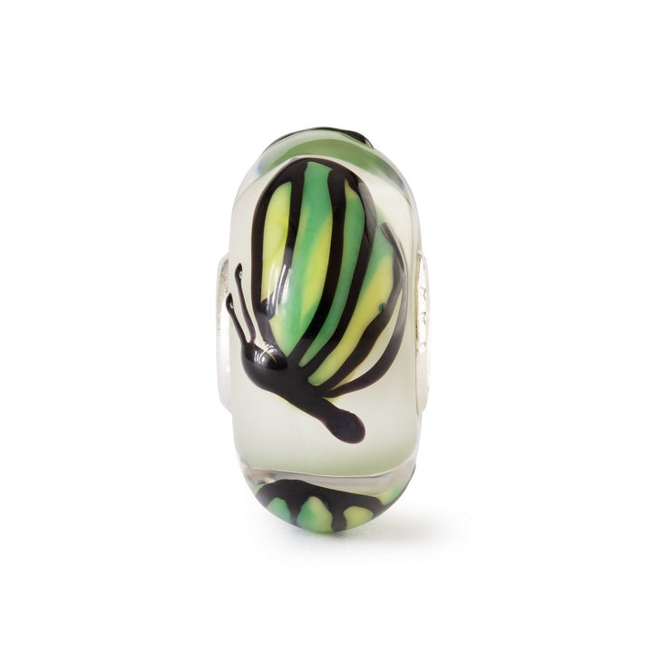 Glass charm with green and black abstract design on a white background