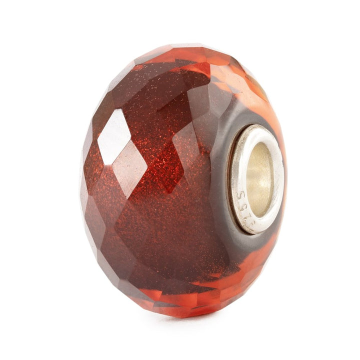 Faceted red and silver bead on a white background