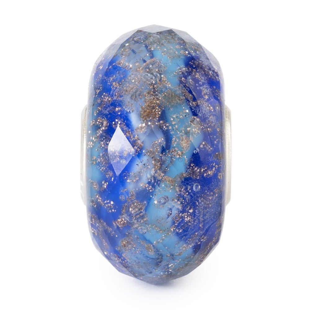 Blue glass bead with silver flecks on a white background