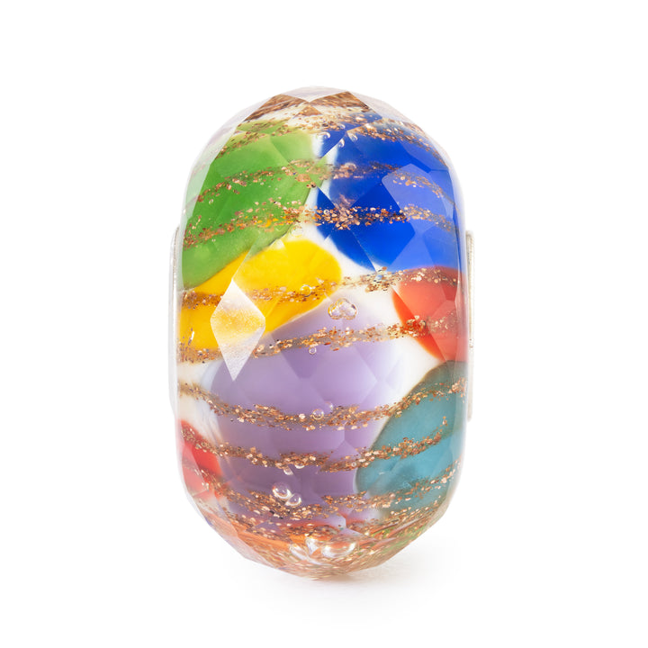Multicolored glass bead with gold accents on a white background