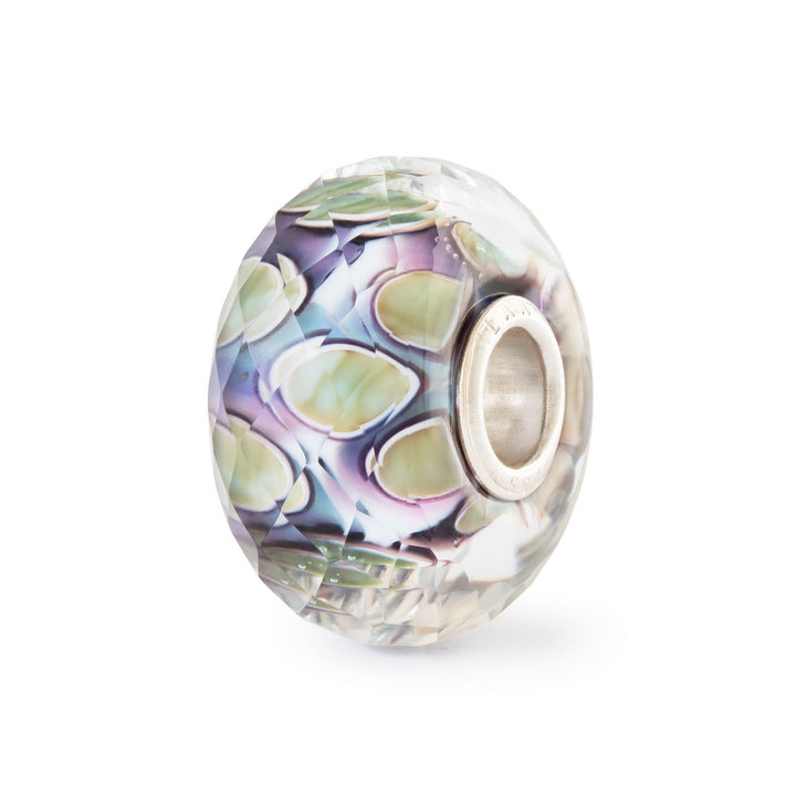 Multicolored glass charm with silver core on a white background