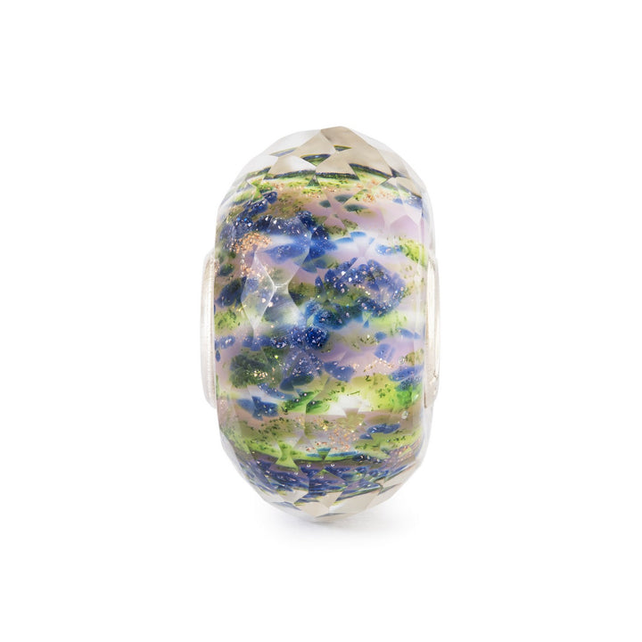 Decorative glass bead with floral pattern on a white background