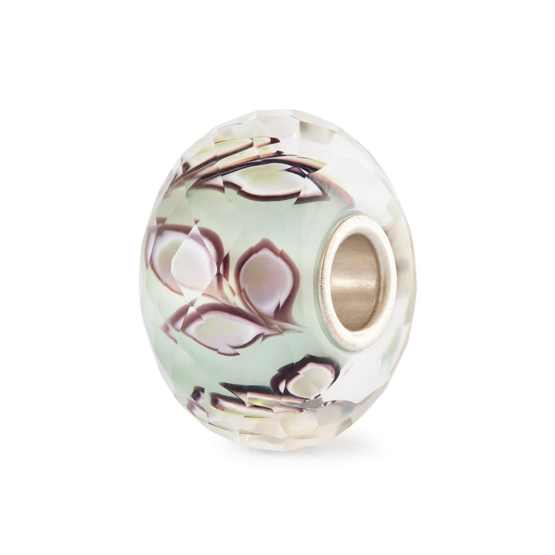 Decorative bead with floral pattern on a white background