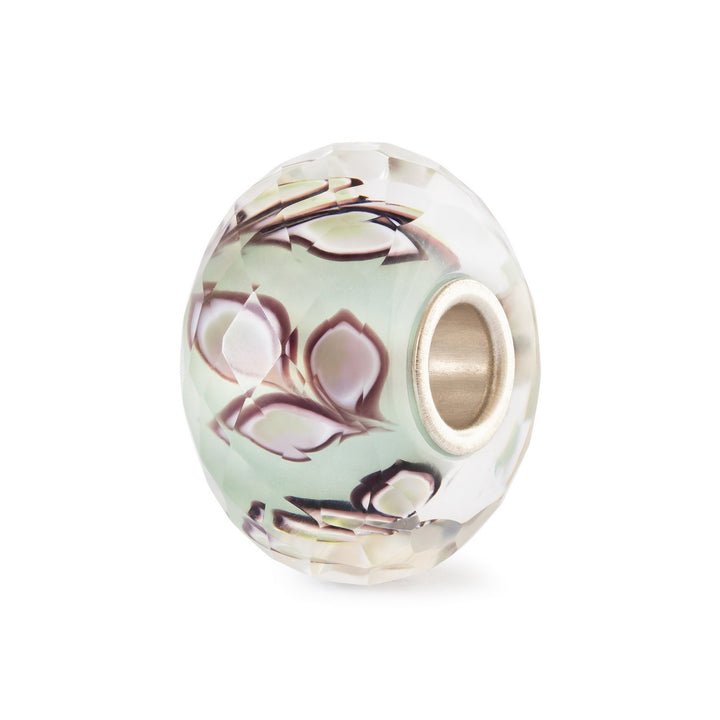 Decorative bead with floral pattern on a white background
