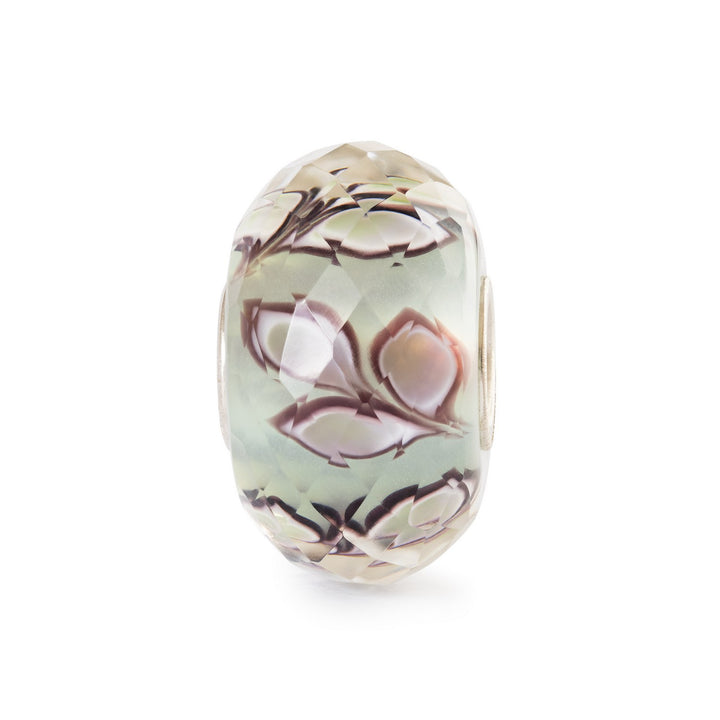 Decorative bead with floral pattern on a white background