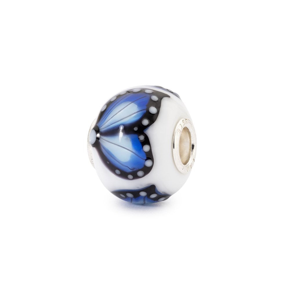 Glass charm bead with blue butterfly design on a white background