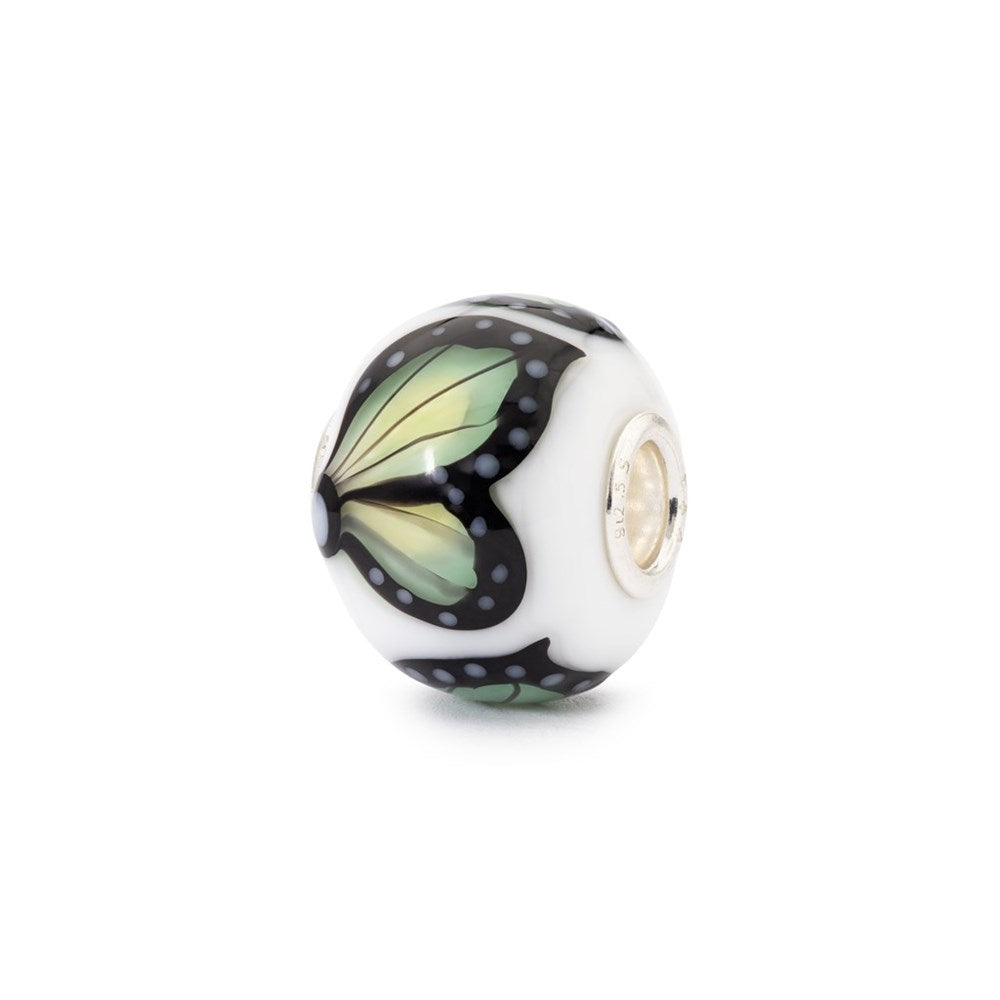 Butterfly-themed glass bead on a white background