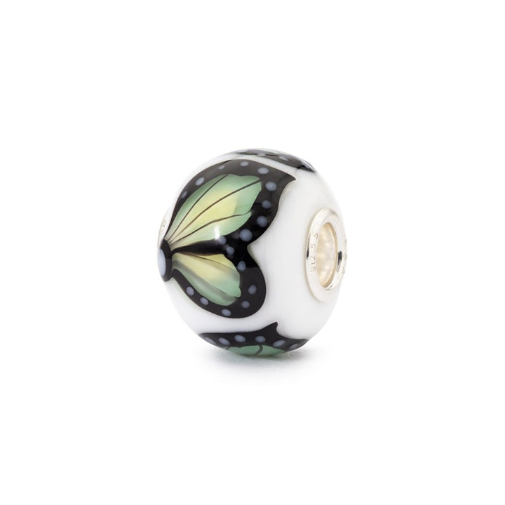 Butterfly-themed glass bead on a white background