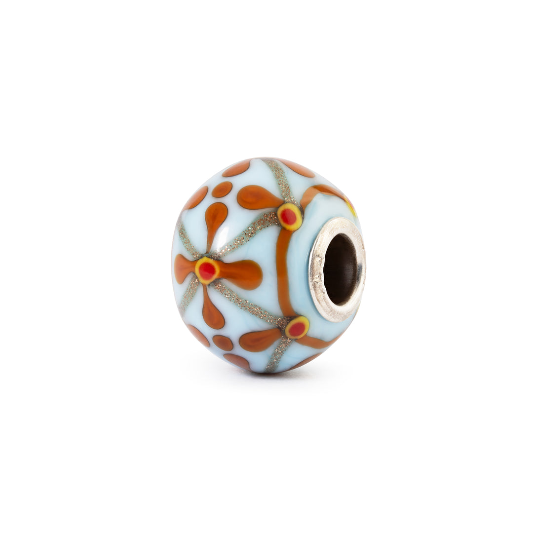 Decorative bead with floral pattern on a white background