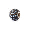 Decorative bead with black, white, and gold pattern on a white background