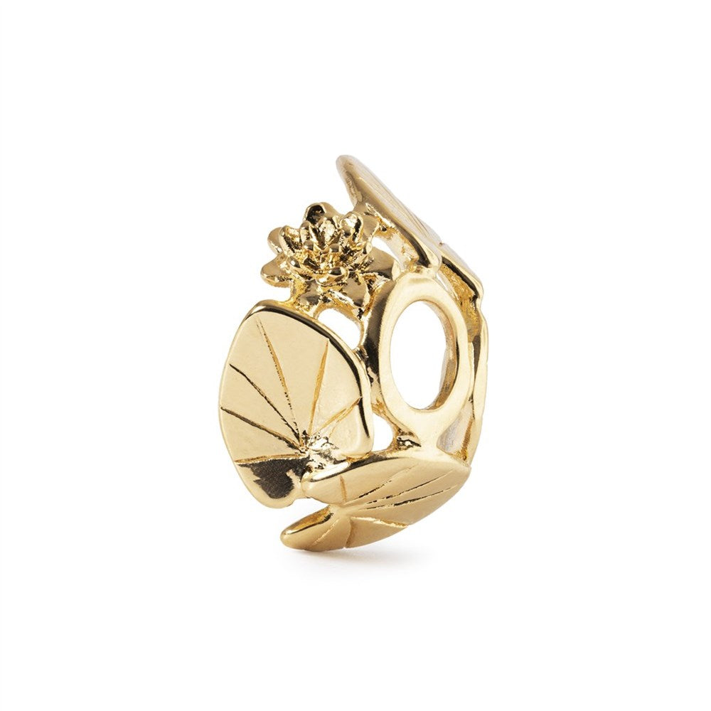 Gold-colored charm with a floral design on a white background