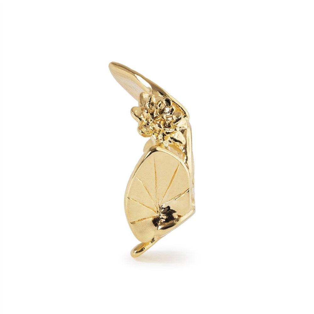 Gold-colored charm with a floral design on a white background