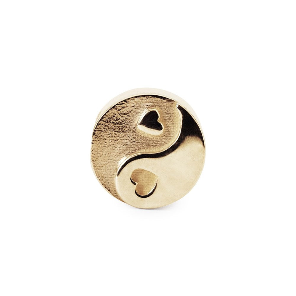 Gold charm with a heart design on a white background