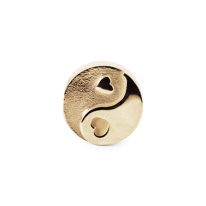 Gold charm with a heart design on a white background