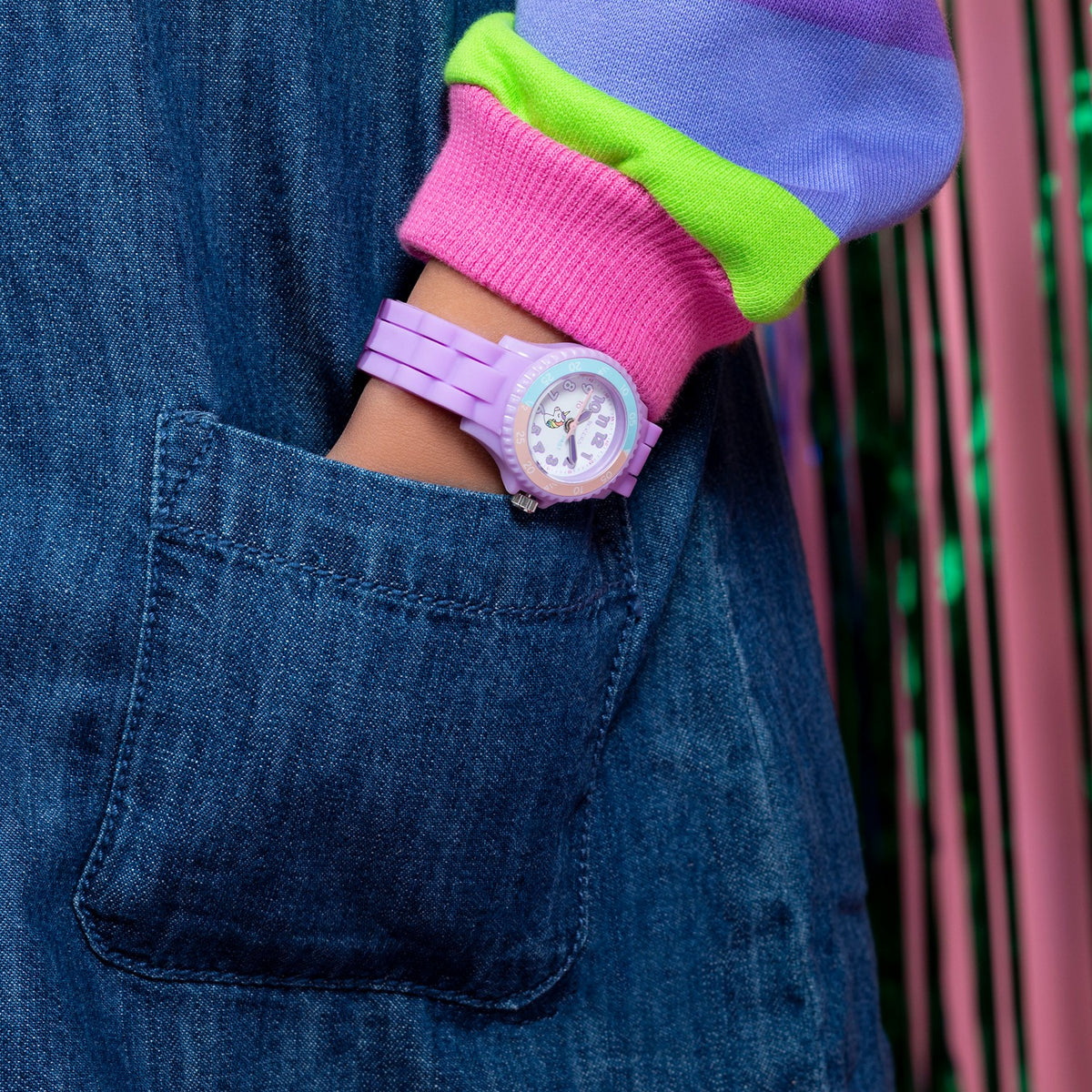 Person wearing a colorful outfit with a purple watch on a blurred background