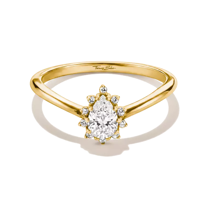 A yellow gold solitaire engagement ring featuring a pear-cut center diamond surrounded by a halo of smaller round diamonds, with a split-shank band. The ring is shown on a clean white background with a soft shadow.
