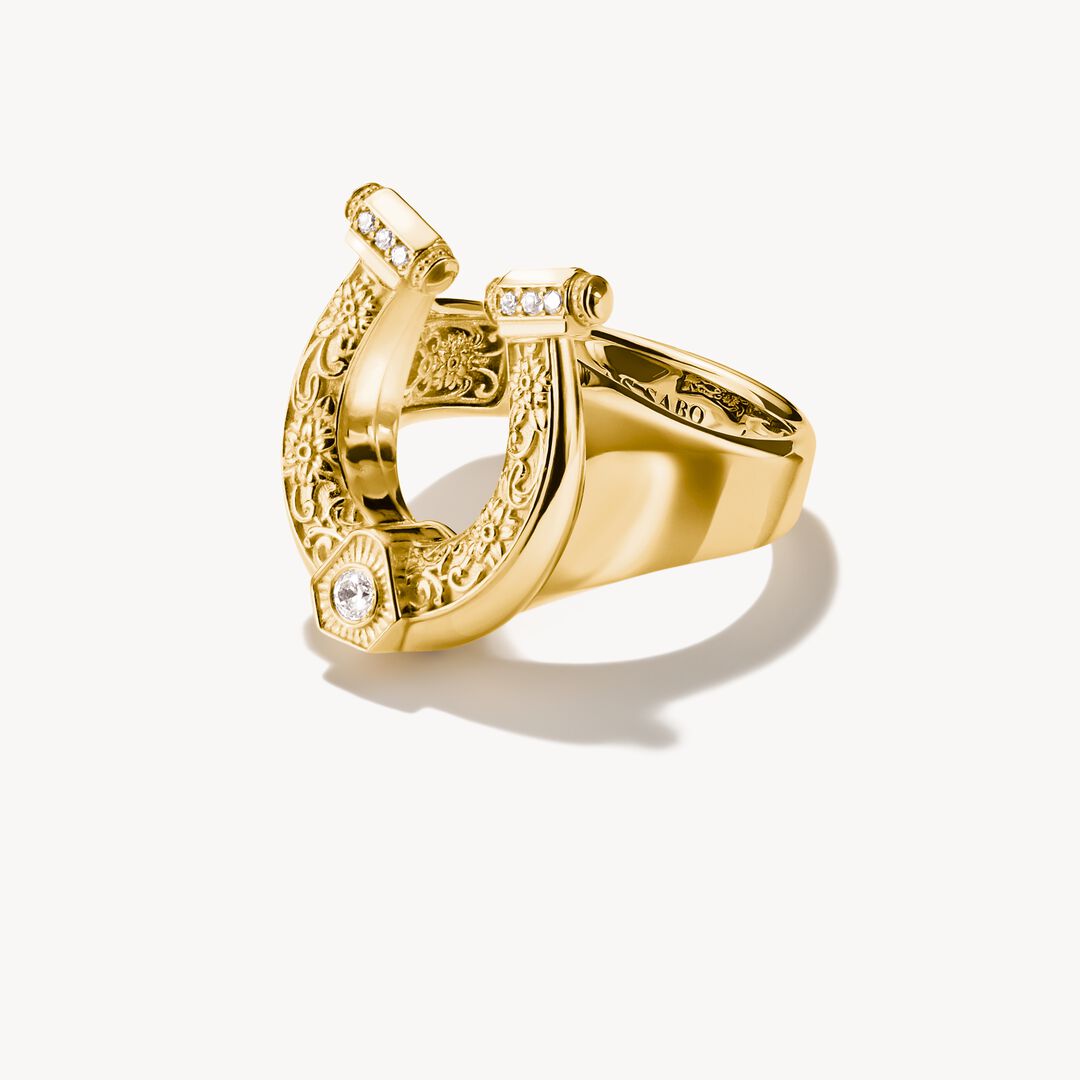 Gold ring with intricate design on a white background