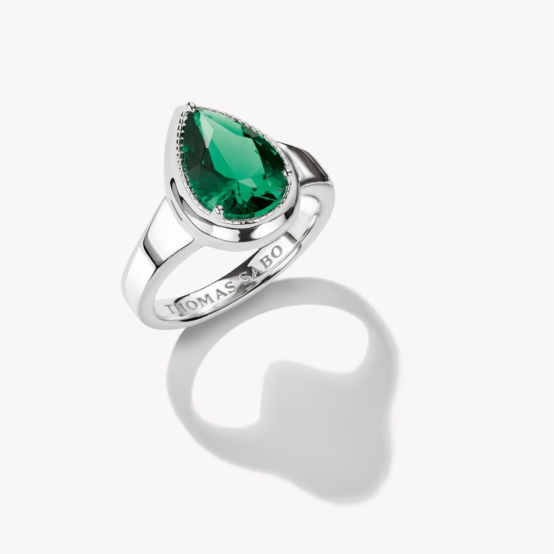 Silver ring with a green gemstone on a white background