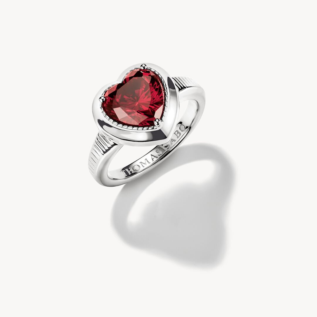 Silver ring with a red gemstone on a white background