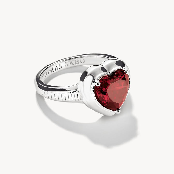 Silver ring with a red heart-shaped gemstone on a white background, featuring the Thomas Sabo brand.