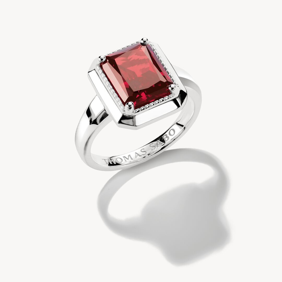 Silver ring with a red gemstone on a white background