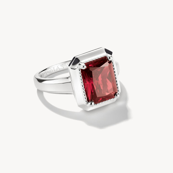 Silver ring with a red gemstone on a white background
