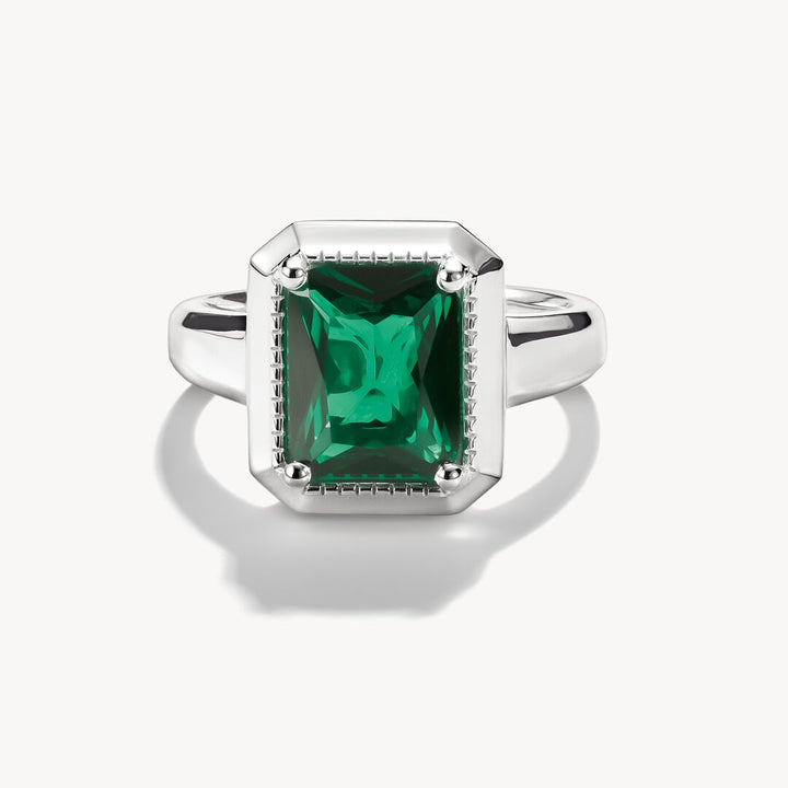 Silver ring with a green gemstone on a white background