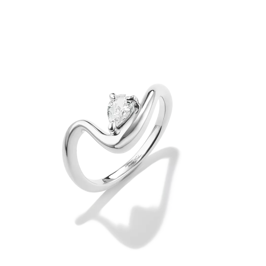 A silver-tone ring featuring a pear-cut clear gemstone in a prong setting, mounted on a sculptural curved band, shown on a white background with a soft shadow.