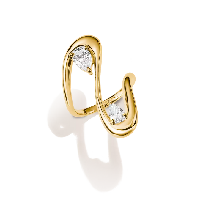 A gold wrap-style ring featuring two marquise-cut clear gemstones, photographed on a clean white background with a soft shadow.