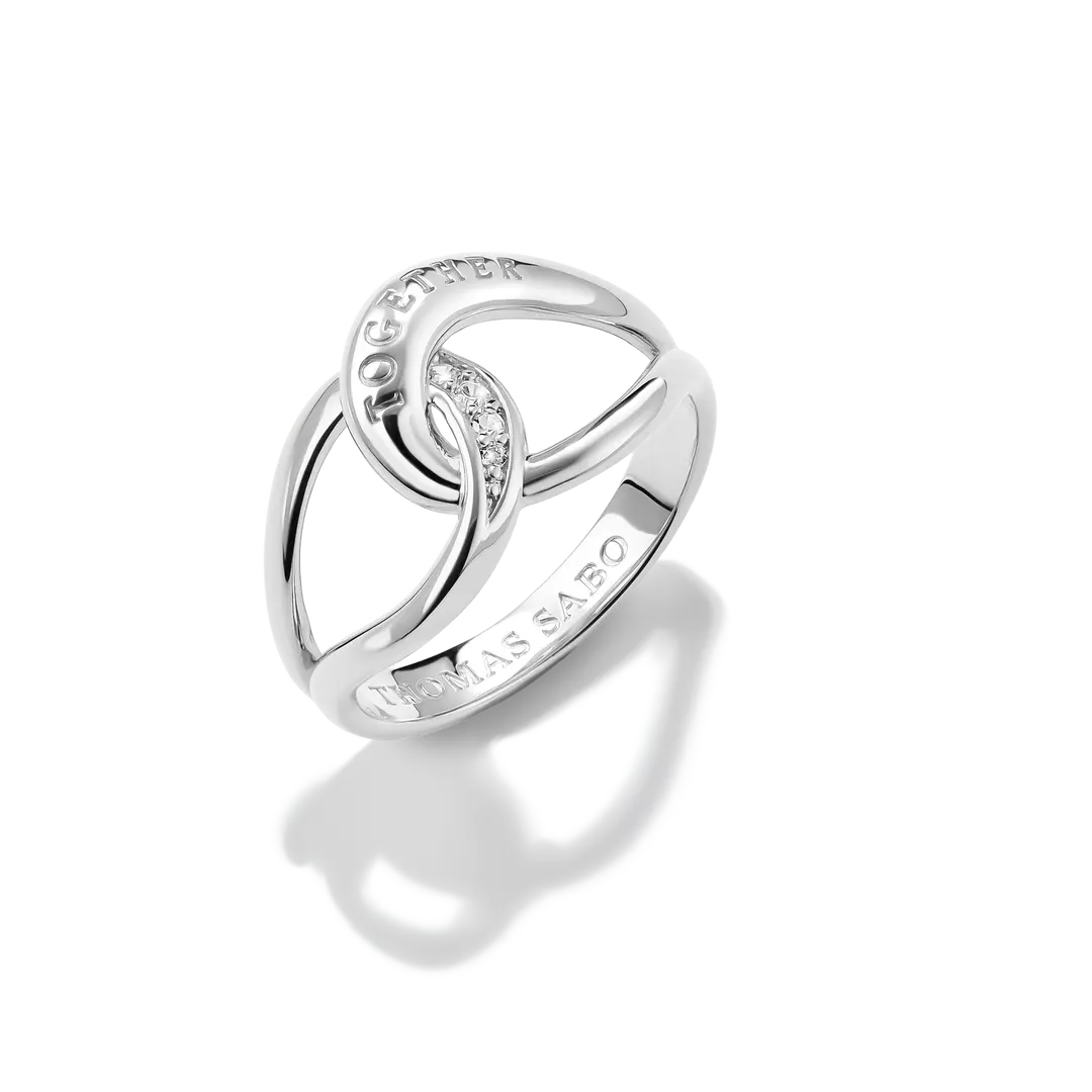 A silver ring by Thomas Sabo featuring interlocking curved bands with a small row of clear stones and the brand name 'THOMAS SABO' engraved on the band, set against a clean white background with a soft reflection.