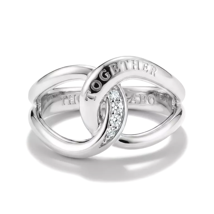 A polished silver interlocking rings ring set with a small pavé diamond accent and engraved with the word 'TOGETHER' on one band, shown on a white background.