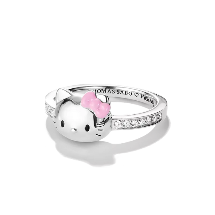 A silver Hello Kitty ring by Thomas Sabo, featuring a polished silver Hello Kitty face with a pink bow and small clear stones along the band, set against a clean white background.