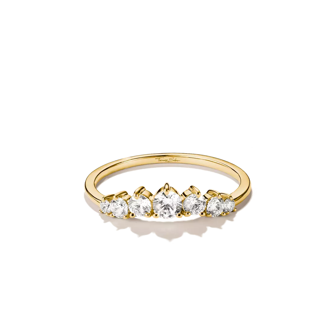 A yellow gold ring featuring five round-cut clear gemstones set in a row, photographed on a clean white background with a soft shadow.