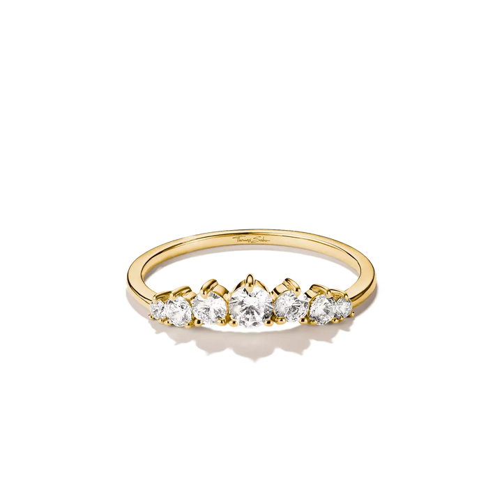 A yellow gold ring featuring five round-cut clear gemstones set in a row, photographed on a clean white background with a soft shadow.