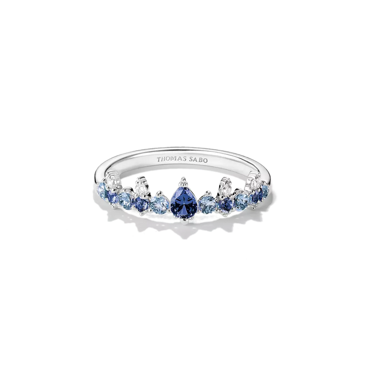 A Thomas Sabo silver ring featuring a row of blue and light blue gemstones, including a central pear-cut blue stone, set against a clean white background.