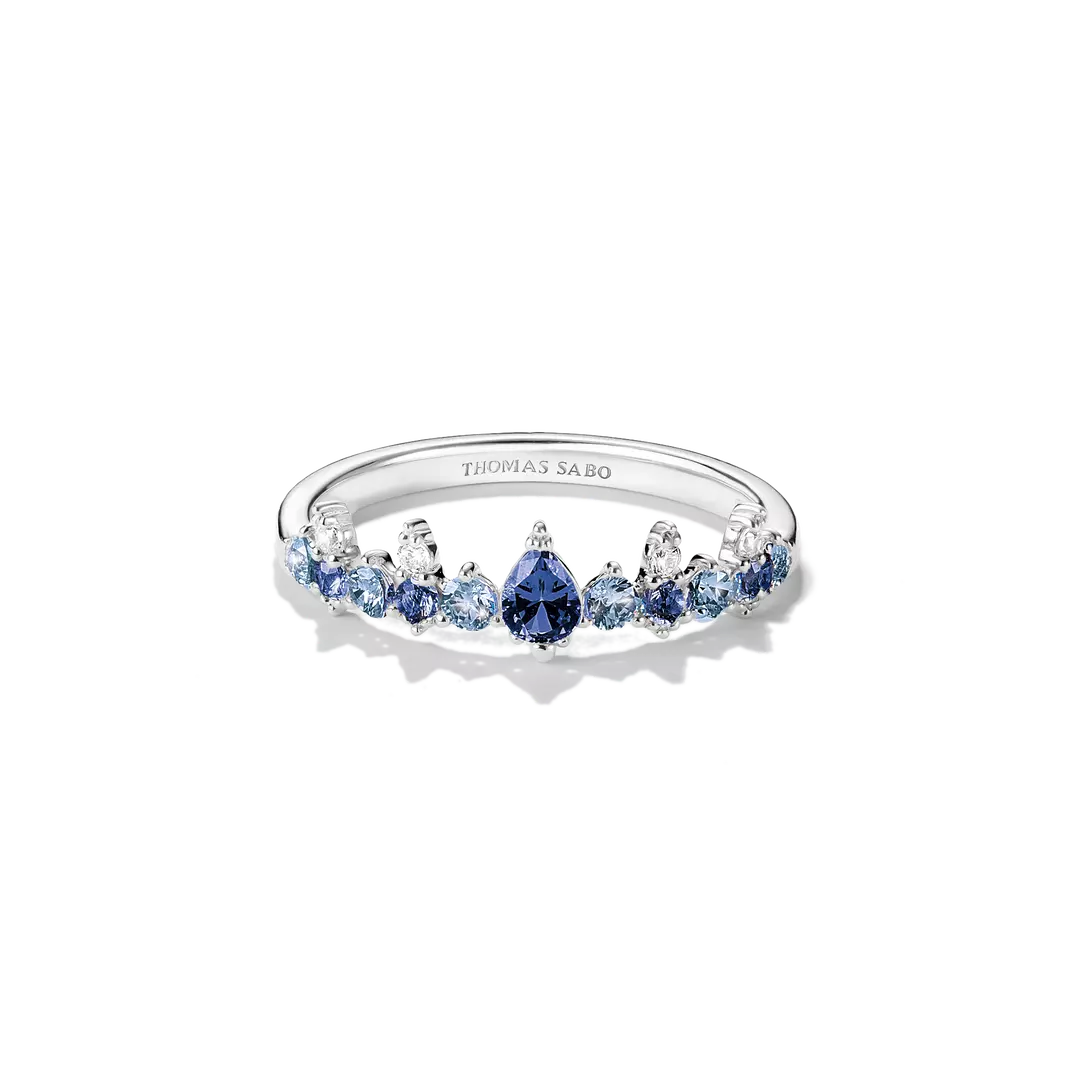 A Thomas Sabo silver ring featuring a row of blue and light blue gemstones, including a central pear-cut blue stone, set against a clean white background.
