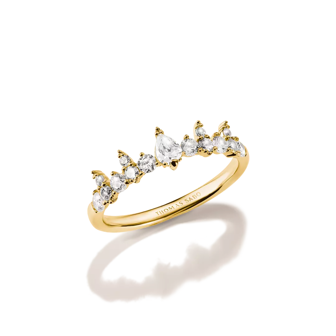 A gold ring featuring a curved row of marquise-cut clear gemstones in a claw setting, photographed on a clean white background with a soft shadow and reflection.