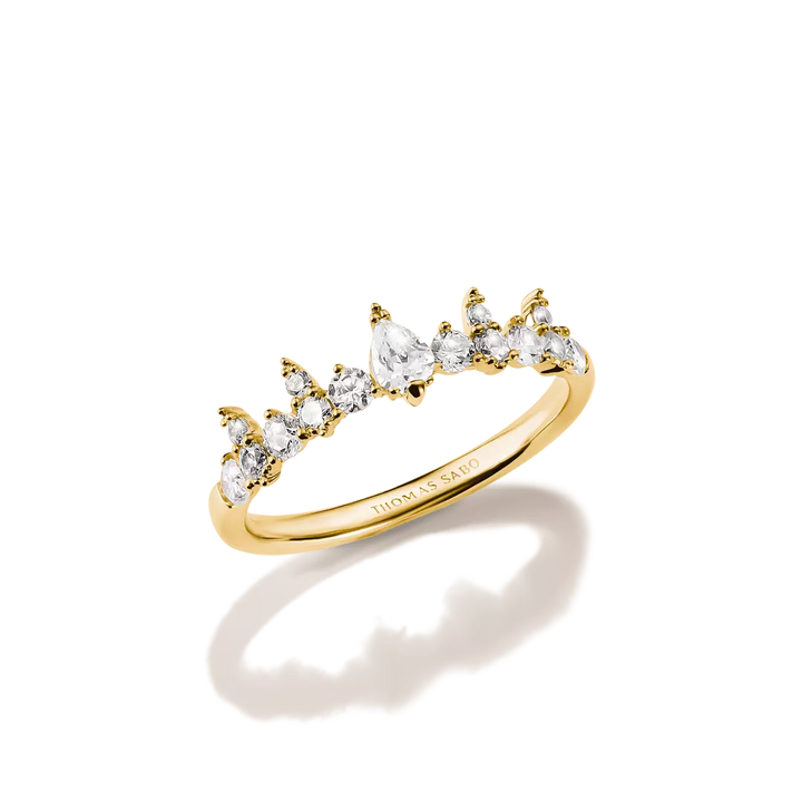 A gold ring featuring a curved row of marquise-cut clear gemstones in a claw setting, photographed on a clean white background with a soft shadow and reflection.