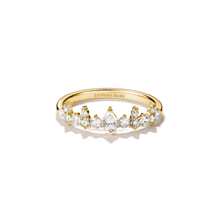 A gold ring with a row of clear gemstones, featuring a pear-shaped center stone, photographed on a clean white background. The inside of the band is engraved with the brand name THOMAS SABO.