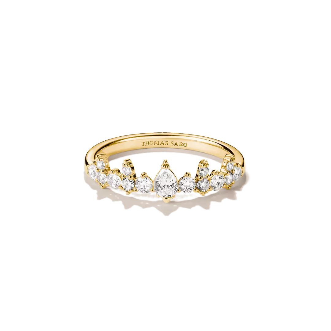 A gold ring with a row of clear gemstones, featuring a pear-shaped center stone, photographed on a clean white background. The inside of the band is engraved with the brand name THOMAS SABO.