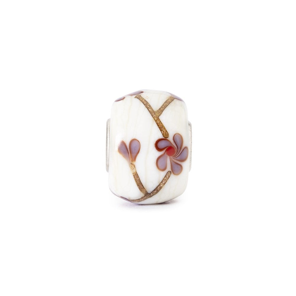 Decorative bead with floral design on a white background