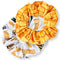 Two scrunchies, one yellow and one white with text, on a white background