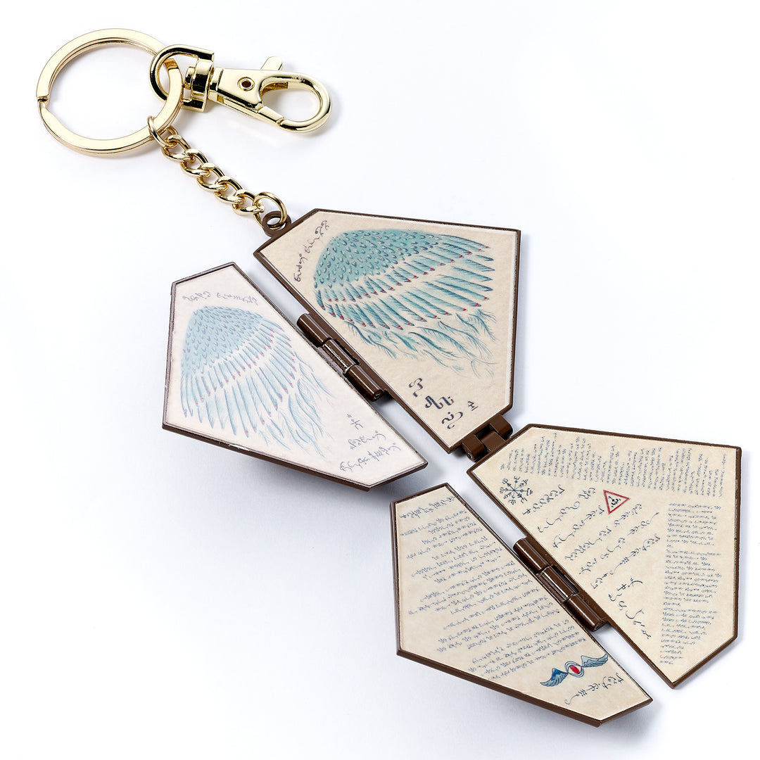 Keychain with open book design featuring text and illustrations on a white background