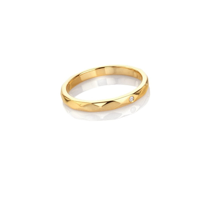 Gold ring with a small diamond on a white background
